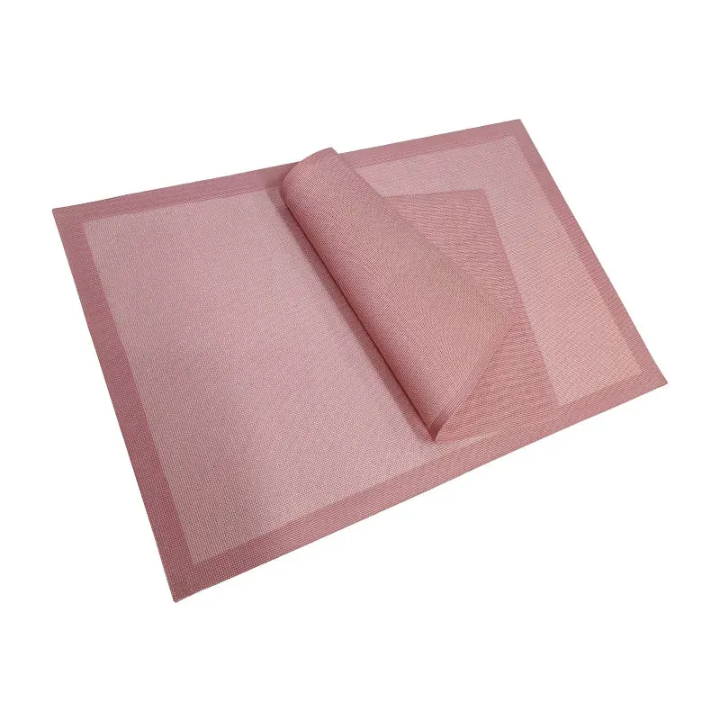 Pink silicone mesh baking mat rolled to show flexible mesh structure