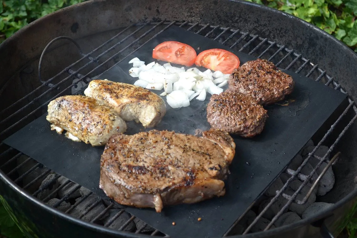 Non stick PTFE grill mat used on outdoor BBQ grill with food