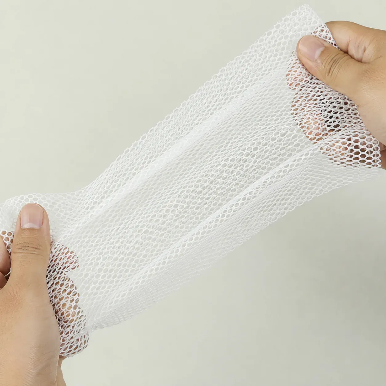 Flexible silicone mesh dehydrator mat held to show its open structure